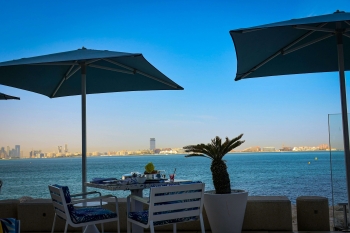 tables and chairs in a restaurant looking out over the water in Dubai